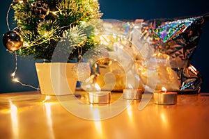 Christmas tree background with copy space. Golden lights LED on Christmas tree and candles reflected in silver wrapping