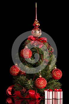 Christmas tree, beautifully decorated small boxes with gifts, isolated on black