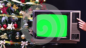 Christmas tree behind vintage old tv with green screen