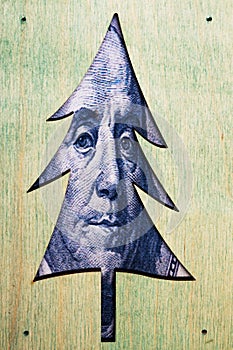 Christmas tree with benjamin franklin`s face with one hundred dollar bill