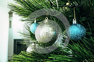 Christmas tree with blue and silver decorations in a bright room