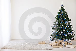 Christmas tree with blue in a white room with toys for Christmas