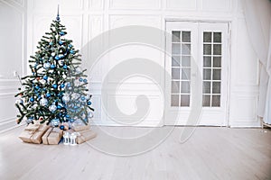Christmas tree with blue in a white room with toys for Christmas