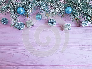 Christmas tree branch, ball, creative gift box ornament on a pink wooden background composition