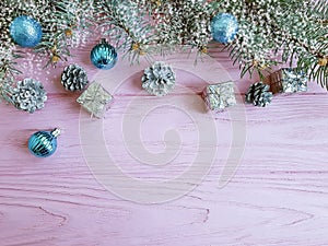 Christmas tree branch, ball, creative season gift box ornament on a pink wooden background composition