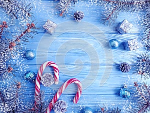 christmas tree branch, ball, snow on blue wooden background, frame, candy, lollipop, sweet