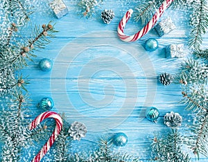 christmas tree branch, ball, snow decor on blue wooden background, frame, candy, lollipop, sweet