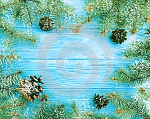 Christmas tree branch on a blue wooden decoration snow background frame