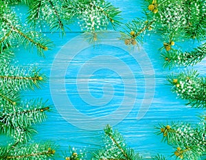 Christmas tree branch on a blue wooden holiday decoration snow background frame