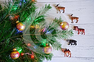 A Christmas tree branch decorated with toys and lights next to a
