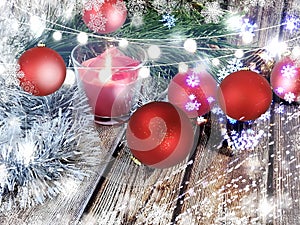 Christmas tree branch and red ball with silver and gold decoration ,candle light in glass on wooden top holiday  festive backgroun