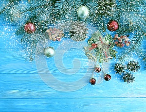 Christmas tree branch on season a blue wooden decorative background, snow, frame, pine cone