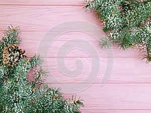 Christmas tree branch seasonal decoration snow border winter on a pink wooden background frame