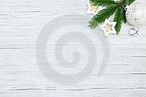 Christmas tree branch, star light garlands and christmas glass ball on white wooden boards