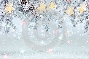 Christmas tree branch under snow decorated with glowing star lights garland