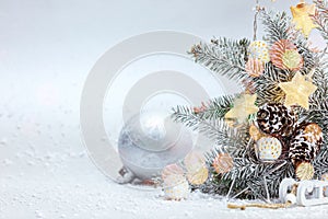 Christmas tree branch under snow decorated with star lights and silver ball