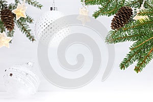 Christmas tree branch, white glass balls and star light garlands. winter holiday background