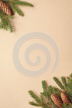 Christmas tree branches on brown paper background, spruce twigs and cones flat lay, copy space