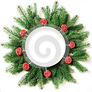 Christmas tree branches and red lolipop as decor on a white background. View from above.