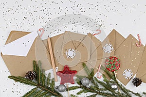 Christmas tree branches, red lollipops and decorations with envelopes on white background