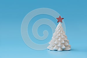 Christmas tree candle  on blue background. Christmas or New Year celebration concept. Copy space