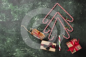 Christmas tree from candy canes and boxes with gifts on a green