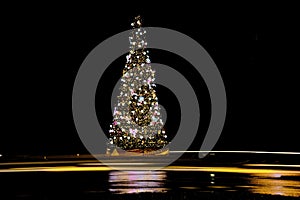 Christmas tree card background. Gold Christmas tree as symbol of Happy New Year, Merry Christmas holiday celebration. Golden light