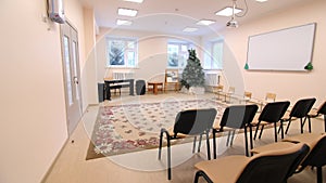 Christmas tree and chairs before children matinee in daycare