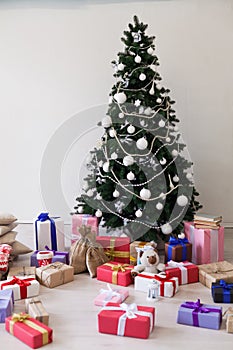 Christmas tree with Christmas gifts in white room