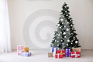 Christmas tree with Christmas gifts in white room