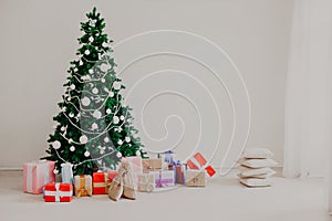 Christmas tree with Christmas gifts in white room