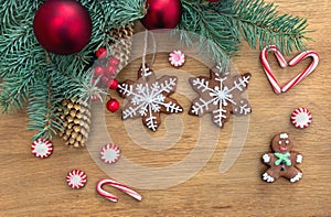 Christmas tree with christmas gingerbread, red balls, candy and cones spruce on a wooden background