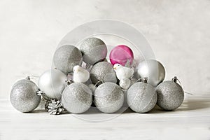 Christmas tree Christmas New Year silver and pink balls and decorative birds on a light background.