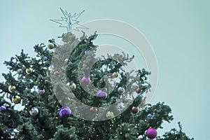 Christmas tree with christmas star, colorful balls, garlands, decorations. Abstract festive background, texture