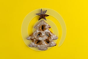 Christmas tree cookies on yellow background. New Year's food. Festive baked goods. Gingerbread on the table. Icing sugar