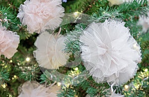 Christmas tree decorated with garland and white fatin bows