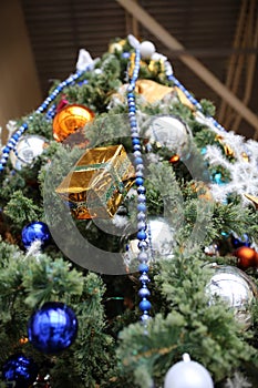 Christmas tree decorated with garlands, Christmas balls and toys in package