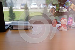 christmas tree decorated with gift box snowman on office desk