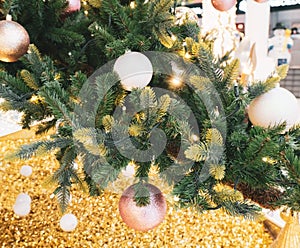 Christmas tree decorated with golden balls and glitters close up, festive background
