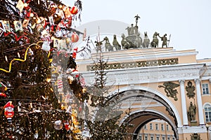 The Christmas tree is decorated with lamps and toys against sculpture on arch of the General Staff Building. The Palace Square,