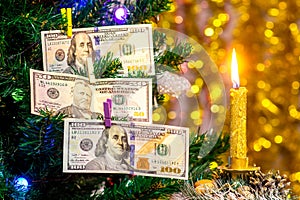 Christmas tree decorated with one hundred dollar bills with candle light_