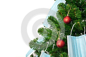 Christmas tree decorated with red ball and blue coronavirus masks