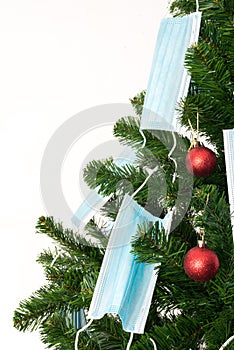 Christmas tree decorated with red balls and blue coronavirus masks