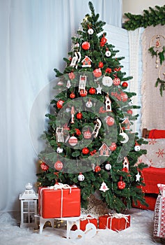 Christmas tree decorated with red knitted toys.