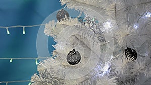 The Christmas tree is decorated with silvery snowflakes and black fishnet balls. Christmas tree with blinking lights and Christmas