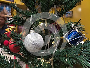 Christmas tree decorated with small silver bells on a shiny rope, round balls. Festive new year christmas decoration background