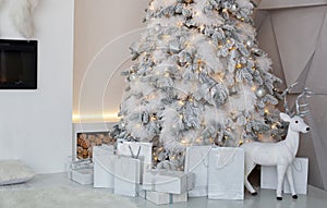 Christmas tree decorated with toys, balls and lights glowing garlands in living room.