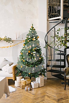 Christmas tree decorated with toys, dried lemons or oranges, garlands in the living room. Scandinavian Christmas style in the