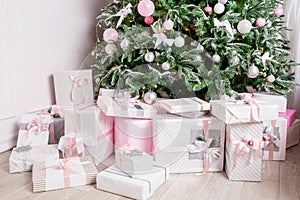 Christmas tree decorated with toys in silver and pink color. In it we see the balloons with of ribbons and lights