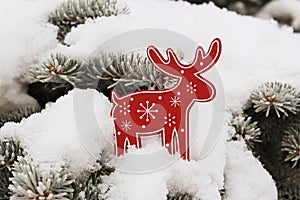 Christmas tree decoration a red deer (elk) on snow on a fir-tree